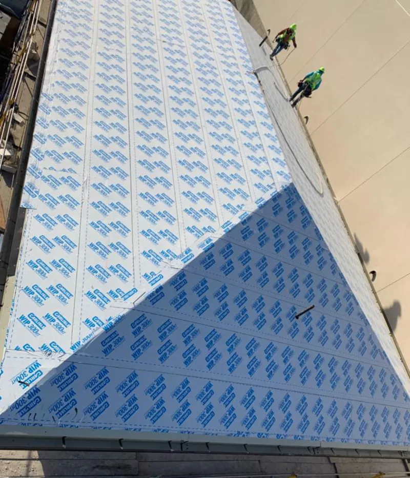 Professional roofers installing underlayment on a metal roof in Hanahan